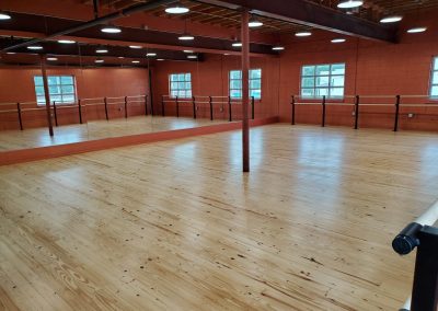 dance studio with wood floor, mirrors and barres